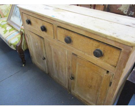 A Victorian pitch pine dresser base/sideboard having two drawers with bun handles above two cupboard doors and one fixed cent