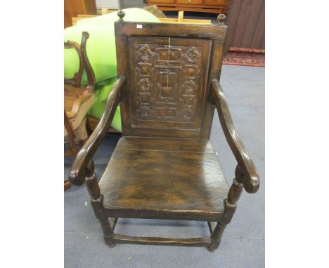 A 20th century oak Wainscot armchair having a carved back panel