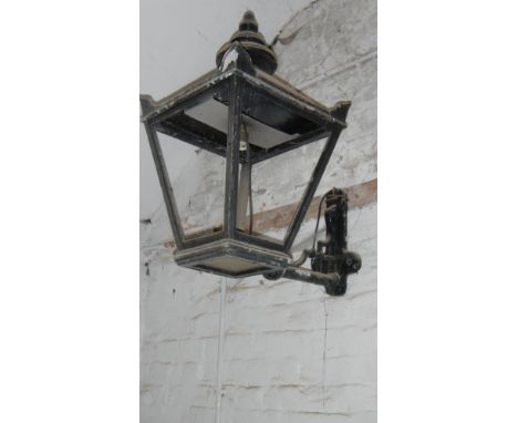 A very large street lamp on wall bracket.