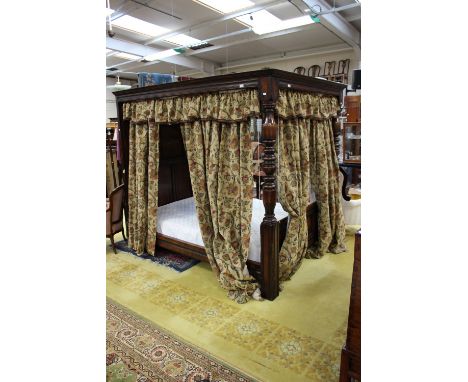 A large 17th Century style oak tester bed with a panelled tester, panelled back, the front with two turned supports
