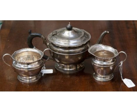 A George V silver three piece tea service, to include tea pot, sugar bowl and cream jug, with egg and dart detail around rim,