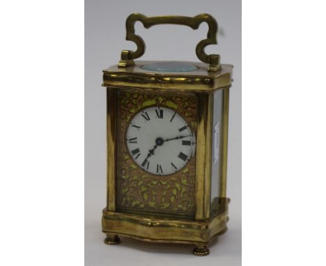 A carriage clock with brass Roman numerals, bevelled glass and enamelled face