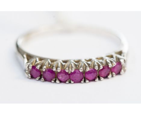 A seven stone ruby dress ring, white metal