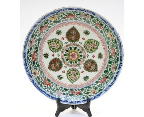 A Chinese polychrome charger, Kangxi, the centre with Islamic style floral motifs bordered in green foliate scroll design and