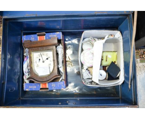 A quantity of compacts to include Stratton, a mantle clock, box of ceramics, all in a large metal trunk.