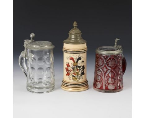 3 Studentika-Krüge. Keramik im Boden undeutlich gemarkt.Farbloses Glas 1x rot gebeizt, je mit Schliff, glasierte Keramik mit 