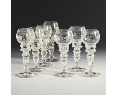 7 Römer mit Weinlaubdekor. Wohl Bayerischer Wald, um 1870.             Farbloses Glas. H 19 cm.             Bauchige Kuppa, m