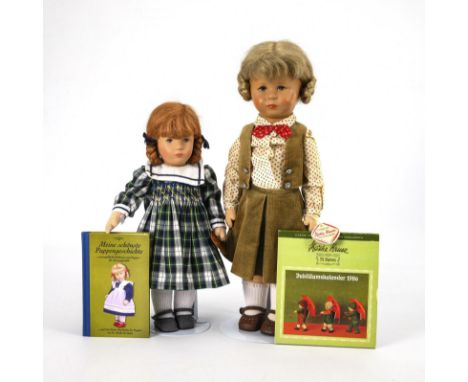 2 Puppen, dazu Kalender und Buch. Käthe Kruse. Unter den Füßen gestempelt. 1x datiert 1998.                         Beide mit