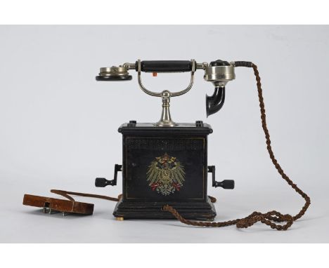 Kurbeltelefon. Beidseitig Reichsadler (Farblithografien). Um 1900.             Holzsockel und -deckplatte, Eisenblech schwarz