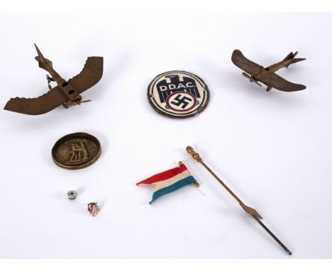 A German WWII Der Deutsche Automobile Club car badge, two trench art planes, a trench art erotic shell end and two other piec