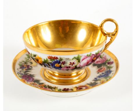 A French porcelain oversize teacup and saucer, circa 1820, painted with a border of summer flowers within gilt rims, and a Sè