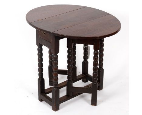 An oak oval two-flap gate leg table, on bobbin turned legs and square stretchers, 59.5cm wide