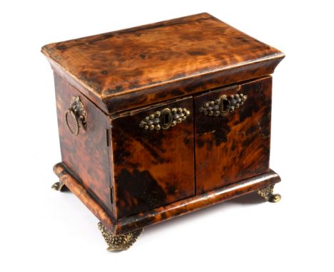 A Regency faux tortoiseshell box, the hinged cover and panel doors to front enclosing compartments and drawers, ring handles 
