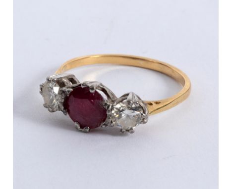 A ruby and diamond three-stone ring, claw set in white metal to a yellow metal shank, size O