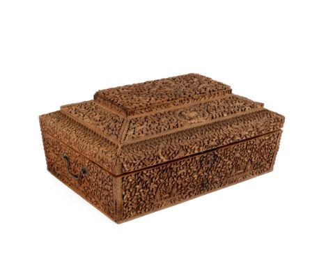 An Anglo-Indian carved sandalwood box, early 19th Century, the removable upper section centred by a family crest, the whole e