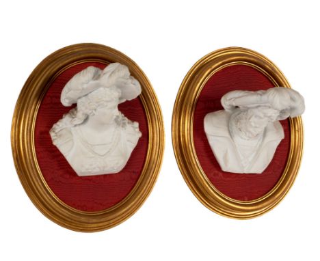 A pair of bisque porcelain wall busts, each depicting a figure in medieval dress, mounted on oval boards in gilt frames/see i