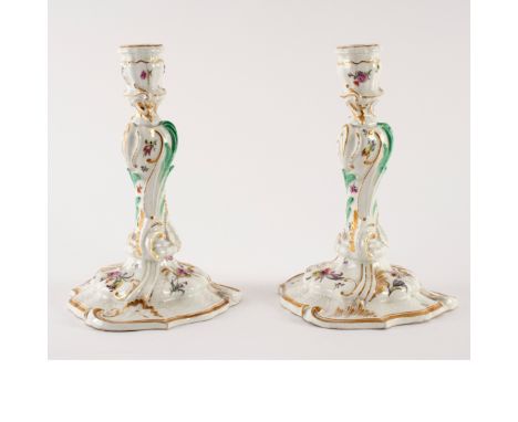 A pair of Meissen porcelain table candlesticks, leaf moulded and of baluster form, the shaped feet moulded with flowers on a 