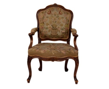 A carved beechwood framed fauteuil with needlework panel back, seat and arms