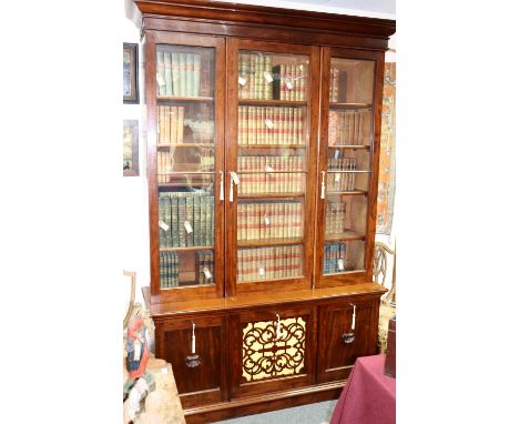 A Victorian mahogany library bookcase, the top enclosed by three glazed doors with cupboards and pierced panel beneath, 169cm