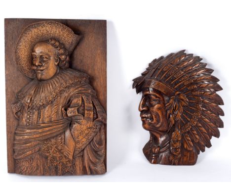 A carved wood panel of a cavalier, 42cm x 27.5cm and a carved head of a native American