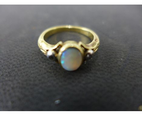 An unmarked presumed 9ct yellow gold ring set with small oval opal flanked by two small diamonds - ring size G - approx weigh