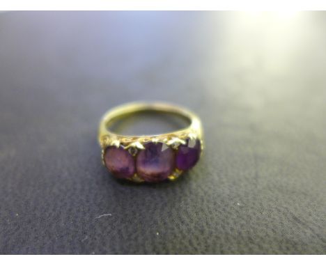 A Ladies 18ct gold amethyst and diamond ring, the larger of the three amethyst stones measuring approx. 8mm x 6mm, set with f