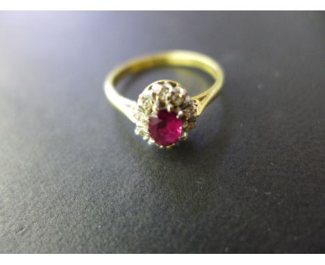 An 18ct gold ruby and diamond oval cluster ring, late 20th century - The oval cut ruby surrounded by ten diamonds, approx tot