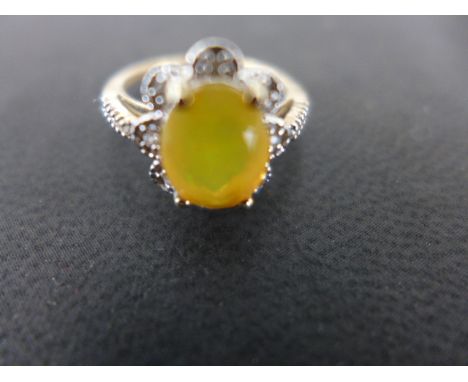 A 9ct yellow gold dress ring the central yellow opal surrounded by small diamonds