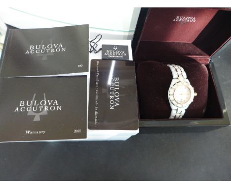 A Bulova white ceramic cased watch model Accutron with white ceramic bracelet, white dial with date aperture at 6 o'clock in 
