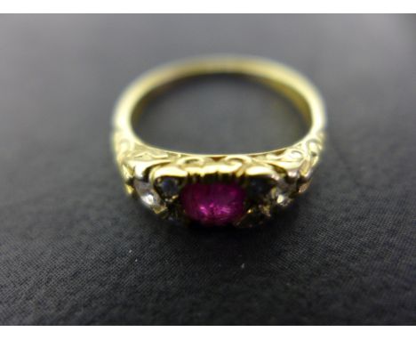 An 18ct gold ruby and diamond ring, set with a central ruby approx. 4mm diameter, flanked by two small diamonds either side, 