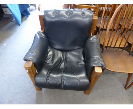 A vintage Arts & Crafts Morris style leather covered hardwood armchair with button decoration, visible front and side straps.