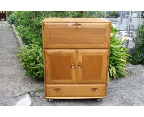 A light elm fall front Ercol bureau,with fitted interior.* Please Note: A further 500 lots from this sale (which are not avai