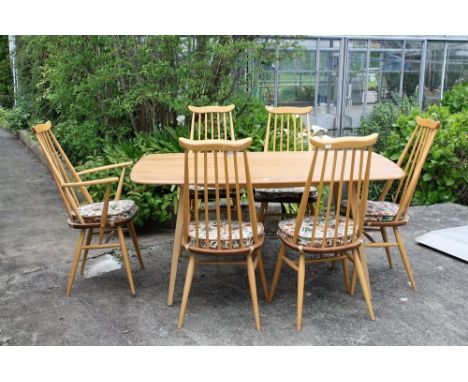 A light elm topped Ercol plank table with six goldsmith chairs.* Please Note: A further 500 lots from this sale (which are no