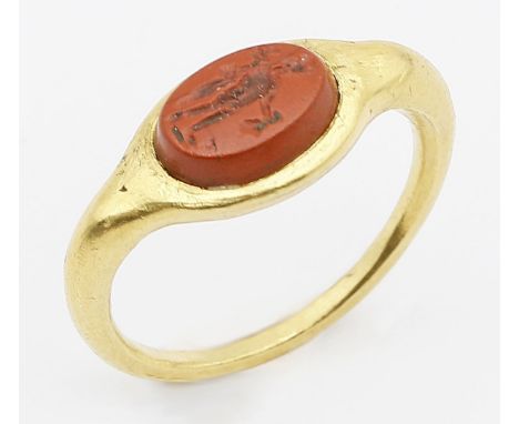 Ring. Mindestens 21,6 kt. GG, geprüft, brutto 4,3 g. Schmaler Reif mit verbreitertem Mittelteil, darauf ovale Gemme aus Jaspi