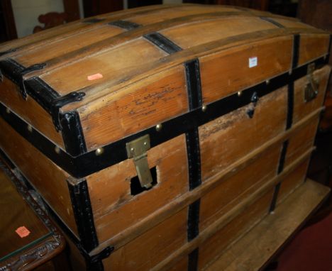 An early 20th century pine and metal bound dome topped travelling trunk having rope twist end carry handles, width 97cm