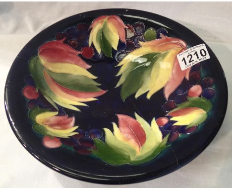 Moorcroft blue ground large footed bowl in the Berries and Leaves pattern, D: 25 cm. Has been in two pieces. P&amp;P Group 2 