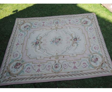 A large needlepoint carpet in the Aubusson style with pink ground and floral detail, 340x200cm approximately