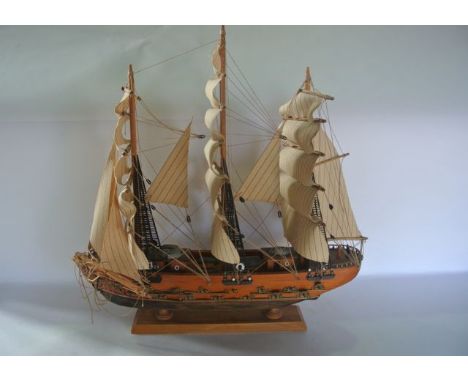 A timber model of a sale ship in full mast with applied detail upon a further timber base, 30 cm tall x 60 cm long approx (AF