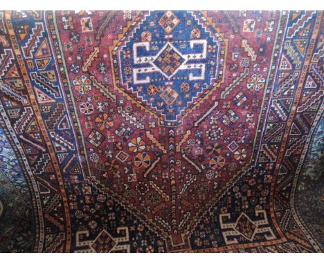 A Persian wool carpet, the central medallion upon a deep red field within alternating borders, 250 x 150 cm