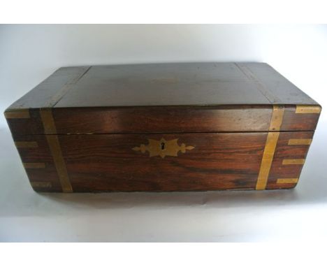 A Victorian rosewood veneered work box of rectangular form with metallic capped corners, banded detail and medallion to the t