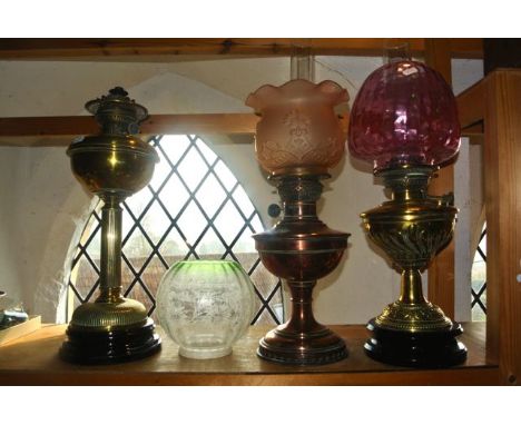 A good quality brass oil lamp upon an ebonised stand with trailing foliate and embossed detail, set within beaded borders and