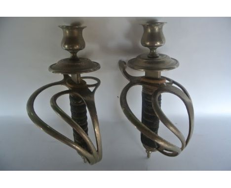 A pair of candlesticks fashioned from infantry sword handles, (Light cavalry officers sword undress pattern 1821) each suppor