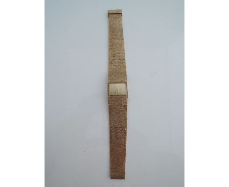 A lady's 9ct gold wristwatch, Bueche-Girod, the gilt rectangular dial with baton numerals, set into an integrated bark textur