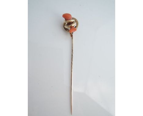 An unmarked 14ct gold stick pin, the scrolling terminal highlighted with a coral branch, contained in a fitted case