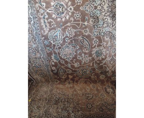 A Persian style wool carpet in tones of beige, the central medallion surrounded by floral detail, set within running borders,