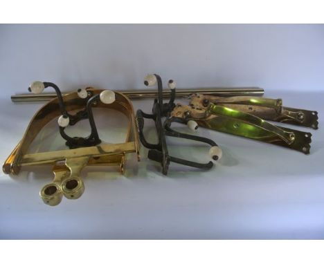 A hanging brass framework consisting of two D shaped ends with attached hooks united by a cylindrical pole together with two 
