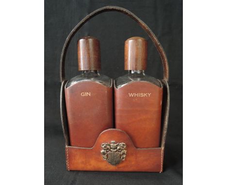A vintage pair of glass flasks, each with timber screw lids, housed in a leather sleeve, one marked Gin, the other marked Whi