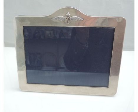 A silver easel back picture frame, London, 1994, the shaped rectangular body highlighted with a mounted RAF motif, 21.5cm wid