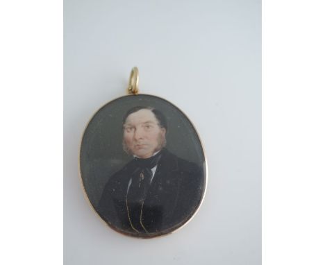 A mid Victorian portrait miniature pendant, of a gentleman in a black jacket, in a plain gold-plated frame, 3.8cm wide