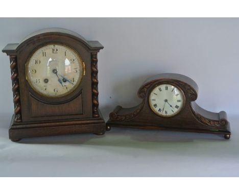 An Edwardian oak mantle clock with engine turned dial, the oak case with barley twist supports enclosing a two train movement